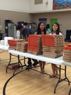 MGC members serve pizza to guests.